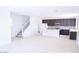 Open living space with light wood floors, white walls, staircase, and view of the modern kitchen at 2445 W Rowel Rd, Phoenix, AZ 85085