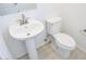 Clean powder room with a pedestal sink, white toilet, neutral walls, and light-colored wood flooring at 2445 W Rowel Rd, Phoenix, AZ 85085