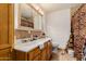 Bathroom with dual sinks, decorative tile, and a large framed mirror at 6908 W Sunnyside Dr, Peoria, AZ 85345