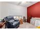 Relaxing bedroom with comfy chair and red accent wall at 6908 W Sunnyside Dr, Peoria, AZ 85345