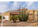 Attractive home with two-car garage, desert landscaping, and solar panels against a bright blue sky at 6908 W Sunnyside Dr, Peoria, AZ 85345