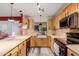 Well-lit kitchen featuring stainless steel appliances, light wood cabinets, and ample countertop workspace at 6908 W Sunnyside Dr, Peoria, AZ 85345