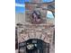 Brick outdoor fireplace with decorative wreath and fire tools at 6908 W Sunnyside Dr, Peoria, AZ 85345