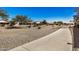 Concrete pathway winds through a desert landscape with residential homes in the background at 5411 W Grenadine Rd, Laveen, AZ 85339