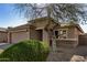 House exterior featuring a two-car garage and a mature tree at 5411 W Grenadine Rd, Laveen, AZ 85339