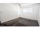 Bedroom with gray carpet, a ceiling fan and access to the bathroom at 6938 E Flossmoor Ave, Mesa, AZ 85208