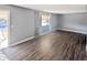 Bright living room featuring wood-look flooring, a large window, and neutral-colored walls at 6938 E Flossmoor Ave, Mesa, AZ 85208