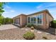 Backyard features desert landscaping, a covered patio, and lush green bushes at 856 E Harmony Way, San Tan Valley, AZ 85140