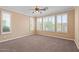 This carpeted bedroom features a ceiling fan and multiple windows with shutters, creating a light and airy feel at 856 E Harmony Way, San Tan Valley, AZ 85140