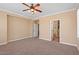 This bedroom showcases neutral carpeting, a ceiling fan, and a doorway leading to additional rooms at 856 E Harmony Way, San Tan Valley, AZ 85140