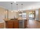 Kitchen island with granite counters, sink, and pendant lights, adjacent to dining area at 856 E Harmony Way, San Tan Valley, AZ 85140