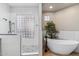 Relaxing bathroom with soaking tub, walk-in shower, and glass block window at 10695 E Caribbean Ln, Scottsdale, AZ 85255