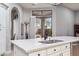 Kitchen island with white cabinets and quartz countertop at 10695 E Caribbean Ln, Scottsdale, AZ 85255