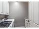 Bright laundry room with white cabinets and washer and dryer at 10695 E Caribbean Ln, Scottsdale, AZ 85255