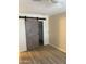 Bedroom with sliding barn door and wood-look tile flooring at 4330 N 5Th Ave # 106, Phoenix, AZ 85013