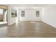 Light-filled living area with wood-look tile flooring, large windows, and backyard access at 4922 W Hunter Trl, San Tan Valley, AZ 85144