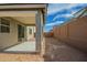 A view of the covered patio and fenced-in yard behind a two-story light grey house at 11632 W Beck Dr, Youngtown, AZ 85363