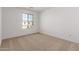 This is an empty bedroom with a tan carpet and bright white walls and trim at 11632 W Beck Dr, Youngtown, AZ 85363