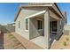 Exterior view of a home's stucco and covered patio and desert landscaping at 5664 N 205Th Ln, Buckeye, AZ 85396
