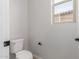 Bright bathroom features a toilet, window, modern fixtures, and neutral decor at 5664 N 205Th Ln, Buckeye, AZ 85396