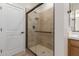 Modern bathroom features a glass-enclosed shower with bronze fixtures and a stone-tiled surround at 5664 N 205Th Ln, Buckeye, AZ 85396