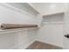 Bright, walk-in closet featuring a carpet flooring and wooden closet rods at 5664 N 205Th Ln, Buckeye, AZ 85396