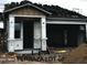 New construction shows in this elevation with an unfinished exterior, showing the roof partially shingled and covered porch at 5664 N 205Th Ln, Buckeye, AZ 85396