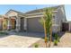 Welcoming home with stone accents, covered entryway, desert landscaping, and two-car garage at 5664 N 205Th Ln, Buckeye, AZ 85396