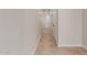 Clean, bright hallway features neutral paint, tiled flooring and white doors at 5664 N 205Th Ln, Buckeye, AZ 85396
