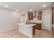 Bright kitchen features an island with sink, stainless steel appliances, and wooden cabinets at 5664 N 205Th Ln, Buckeye, AZ 85396