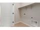 A clean laundry room with tile floor, storage, and laundry hookups at 5664 N 205Th Ln, Buckeye, AZ 85396
