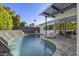 Backyard oasis with a sparkling pool, waterfall feature, shaded patio, and comfortable lounge chairs at 8614 E Berridge Ln, Scottsdale, AZ 85250