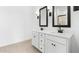Elegant bathroom featuring dual vanities with white countertops, dark fixtures, and sconce lighting for a spa-like ambiance at 16555 N Lunar St, Maricopa, AZ 85138