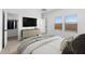 Well-lit bedroom with a sleek dresser, mounted TV, and windows offering natural light, alongside a closet for ample storage at 16555 N Lunar St, Maricopa, AZ 85138