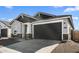 Angle of single-story house with gray-colored 2-car garage and desert landscaping at 16555 N Lunar St, Maricopa, AZ 85138