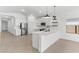Modern kitchen features stainless appliances, white cabinetry, quartz countertops, and bar stool seating at 16555 N Lunar St, Maricopa, AZ 85138