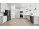 Bright kitchen featuring white cabinetry, stainless steel appliances, and wood-look tile flooring at 16555 N Lunar St, Maricopa, AZ 85138