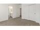 Bright bedroom featuring neutral carpet, access to bathroom, and double door closet at 18440 W Monte Lindo Ln, Surprise, AZ 85387