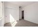 Bedroom with sliding closet doors, neutral carpet, and a bright window at 18440 W Monte Lindo Ln, Surprise, AZ 85387