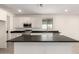 Kitchen features white cabinets, stainless steel appliances, and large island at 18440 W Monte Lindo Ln, Surprise, AZ 85387