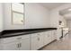 Kitchen area with white cabinets and black countertop with window at 18440 W Monte Lindo Ln, Surprise, AZ 85387