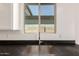 Close up of a kitchen sink with black counters and a window view at 18440 W Monte Lindo Ln, Surprise, AZ 85387