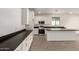 Clean kitchen featuring white cabinets, dark countertops, an island, and stainless appliances at 18440 W Monte Lindo Ln, Surprise, AZ 85387