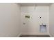 Bright laundry room hookups with tile floors and white walls at 18440 W Monte Lindo Ln, Surprise, AZ 85387