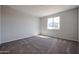 An empty bedroom has neutral carpet, a double-pane window, and light grey paint at 35315 W La Paz St, Maricopa, AZ 85138