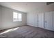 A bright bedroom features neutral carpet, a double-pane window, and light grey paint at 35315 W La Paz St, Maricopa, AZ 85138