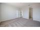 Spacious bedroom with neutral carpet, with a large closet and two white doors at 35315 W La Paz St, Maricopa, AZ 85138