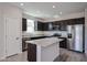 Modern kitchen featuring stainless steel appliances, dark cabinets, and a granite island at 35315 W La Paz St, Maricopa, AZ 85138