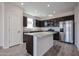 Modern kitchen featuring stainless steel appliances, dark cabinets, and a granite island at 35315 W La Paz St, Maricopa, AZ 85138