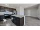 Well-equipped kitchen with stainless appliances, granite counters, and an island overlooking the living space at 35315 W La Paz St, Maricopa, AZ 85138